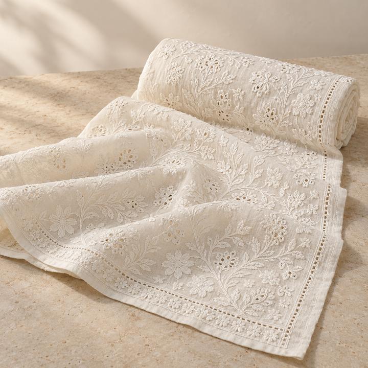 Folded white fabric with white floral embroidery