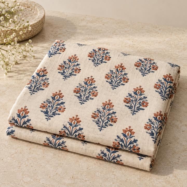 Folded cream fabric printed with rows of blue and red floral motifs