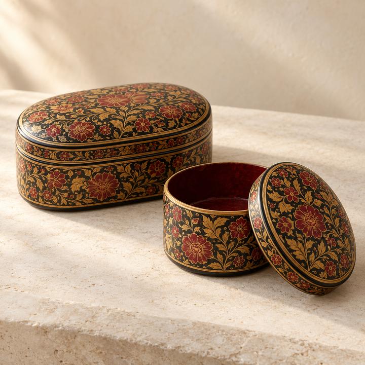 Oval and round lacquered boxes painted with red flowers on a dark background